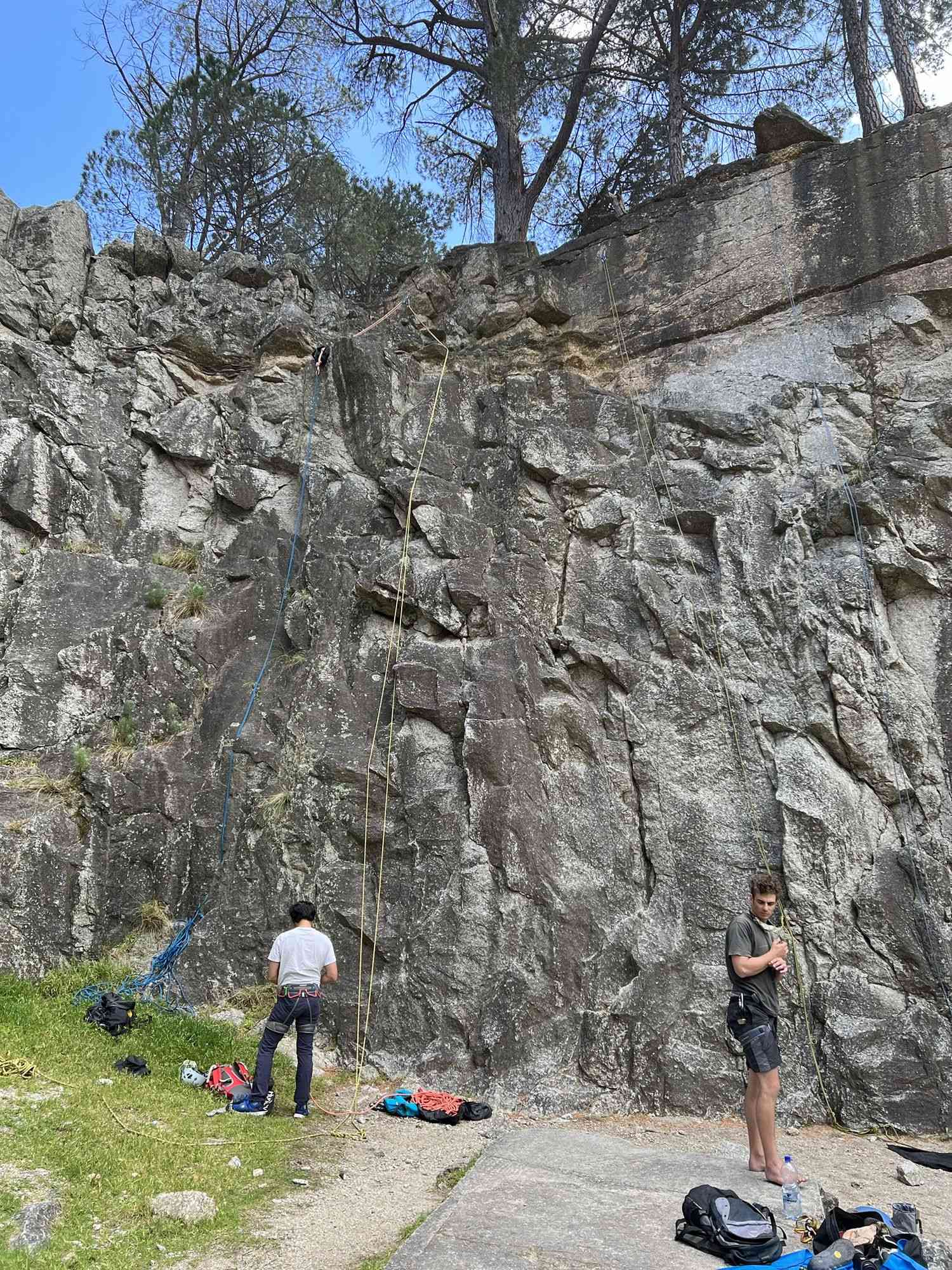 Climbers preparing their gear at the base of a crag