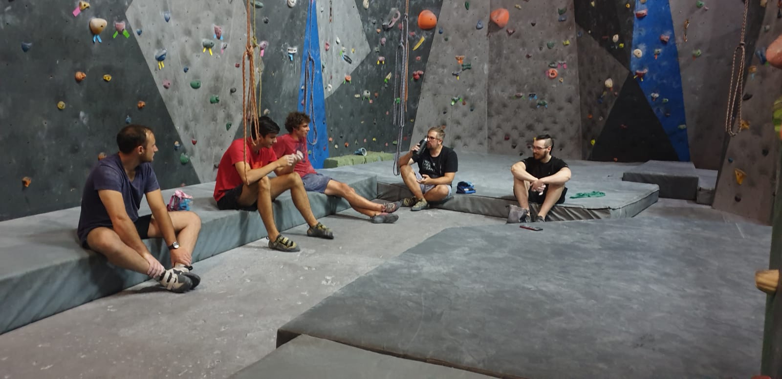 A group relaxing between climbs on the gym mats